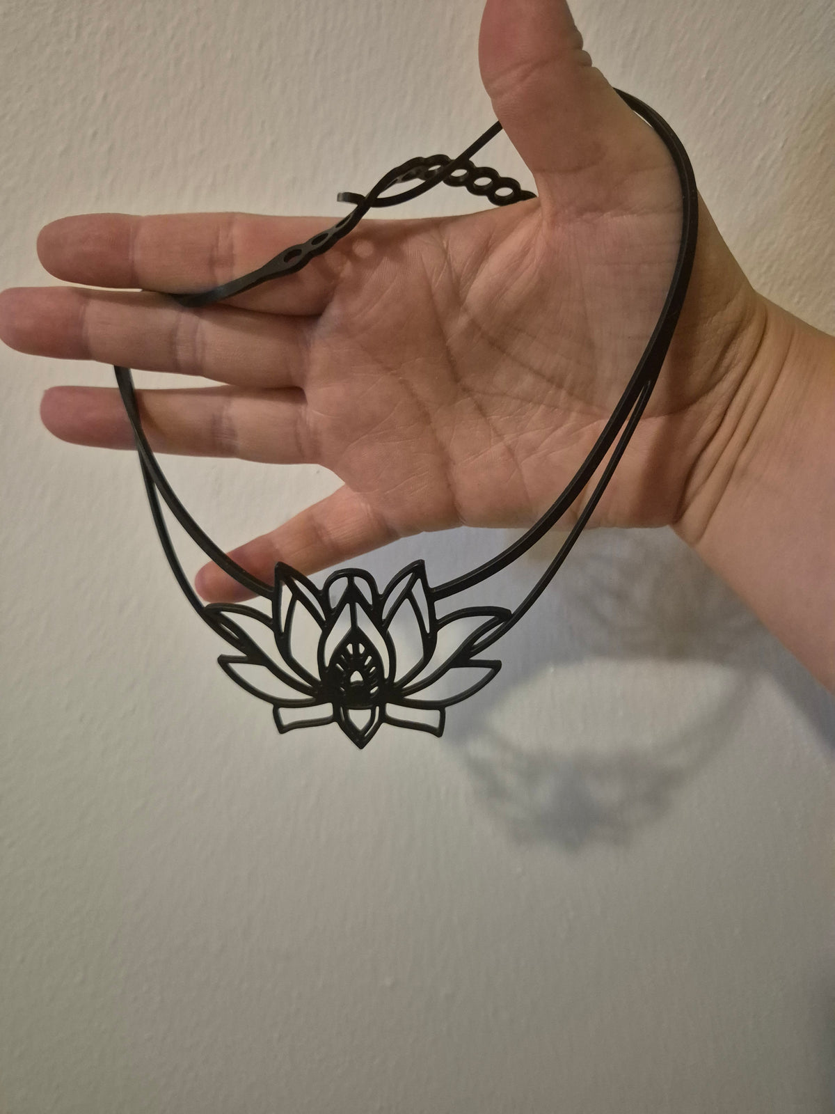 Prachtige zwarte lotusketting in tattoo-stijl.